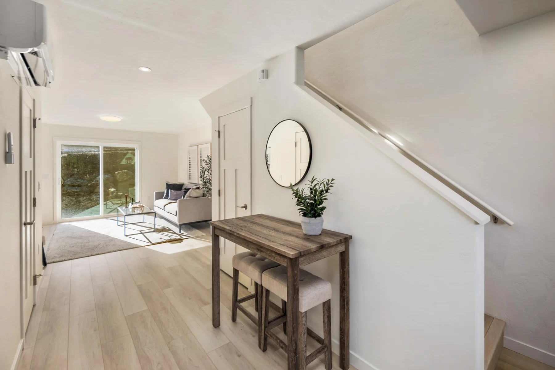 Entry hallway with stairway and a view into the furnished living area